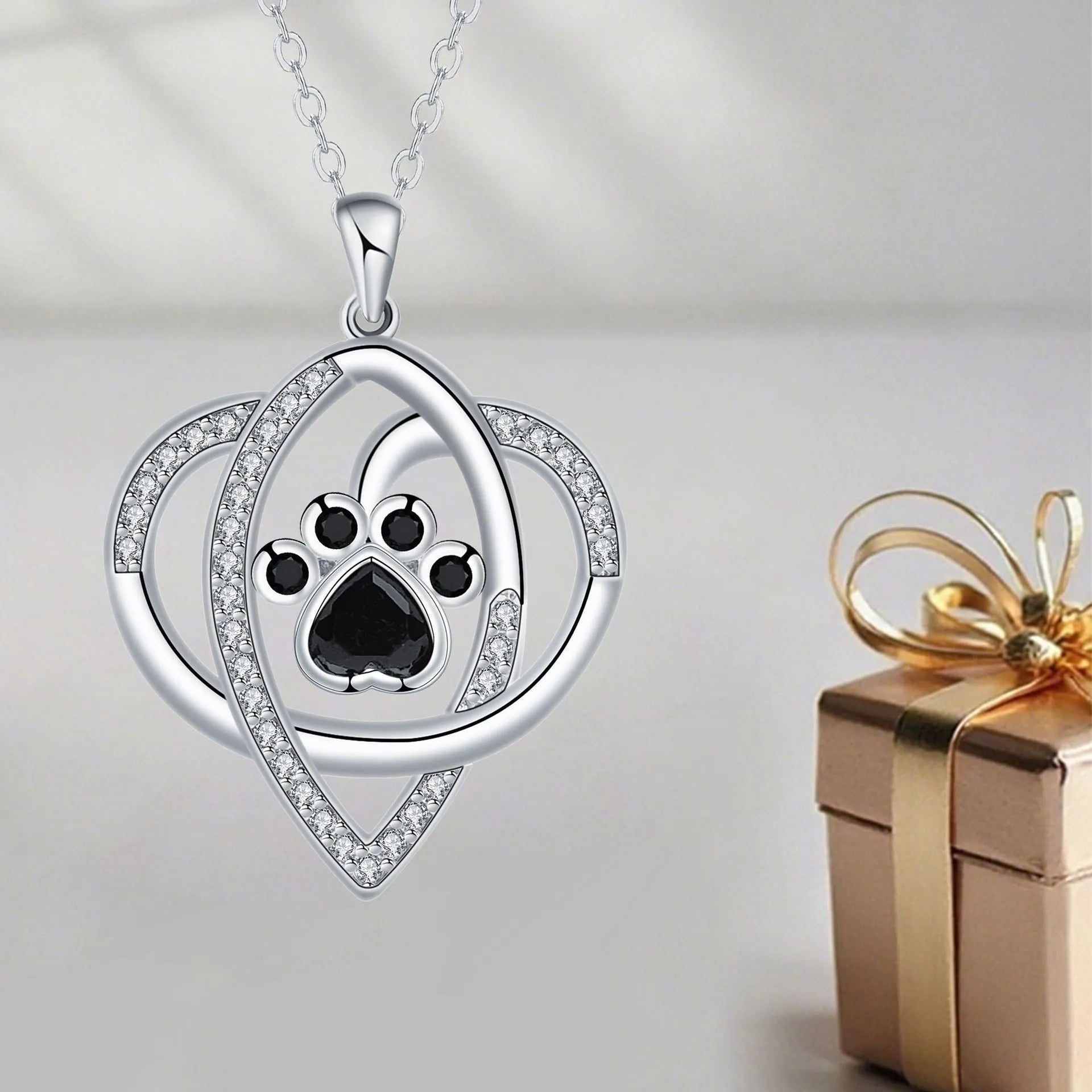 Close-up of electroplated copper paw print necklace pendant on adjustable cross chain