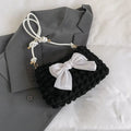Black canvas horizontal square women's handbag with a single shoulder strap and an outer sandwich pocket.