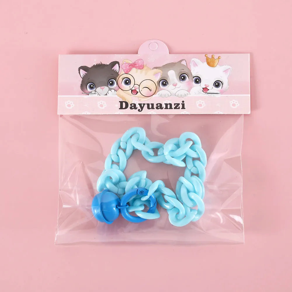 Adjustable plastic pet collar in macaron candy colours on a table, showing chain blue, pink, and mixed colour variants.