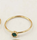 Gold-plated women's knuckle ring with clear stones in green, blue, red, or white on a copper band.