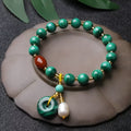 Handmade natural malachite and red agate barrel bead bracelet on a wrist, showing green and red stone details.