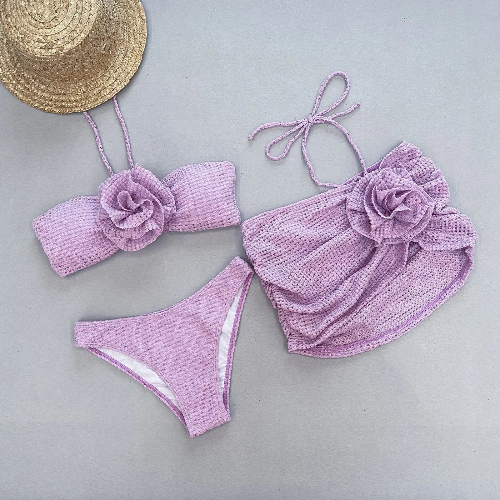 Women's purple three-piece bikini set with 3D flower split detail on a white background