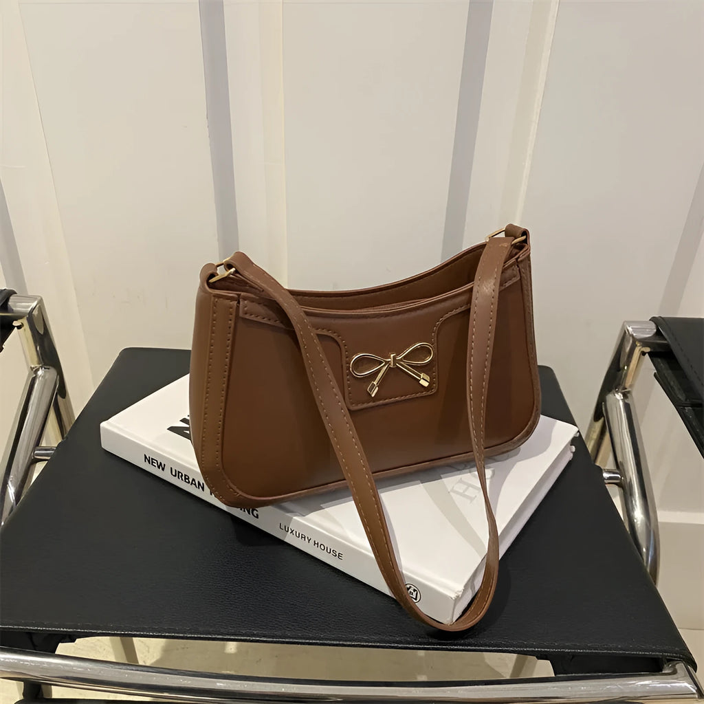 PU leather baguette bag with bow decoration in rose red colour, 24x14x5 cm size on white background