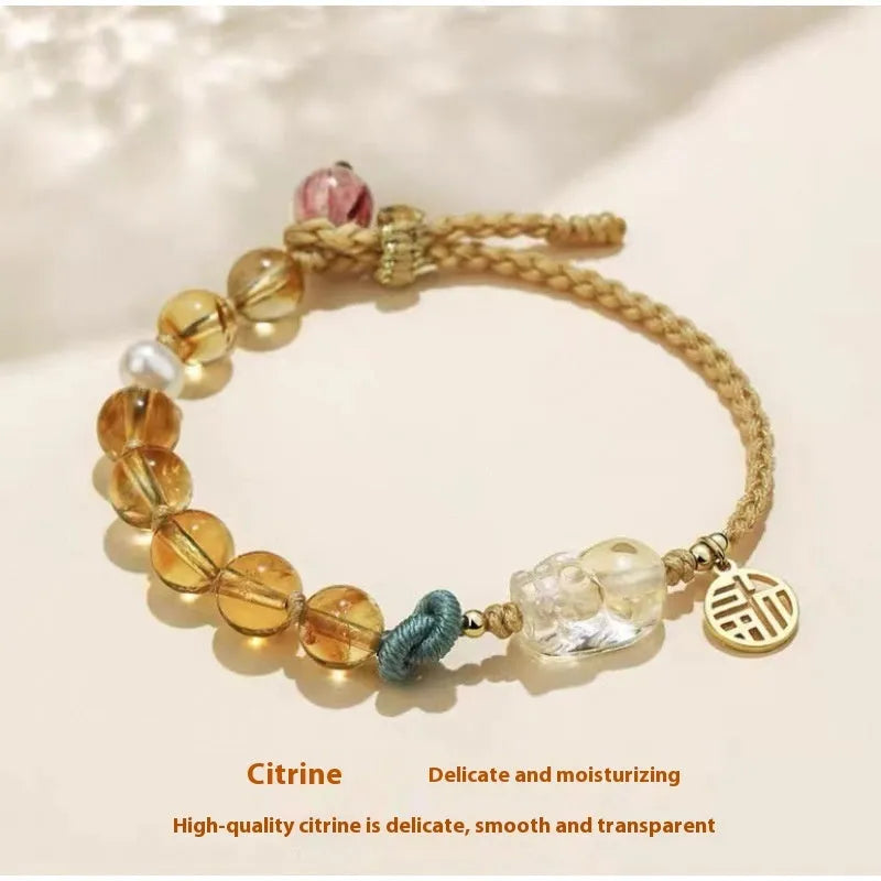 Hand-woven citrine crystal bracelet with zodiac design on neutral background