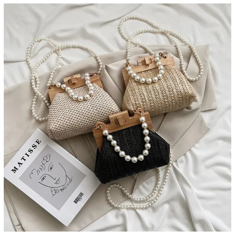 Women's woven straw shoulder bag with pearl chain detailing and multiple interior compartments