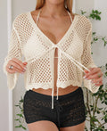 Short apricot women's cardigan blouse with bell sleeves made from thin hollow woven fabric.