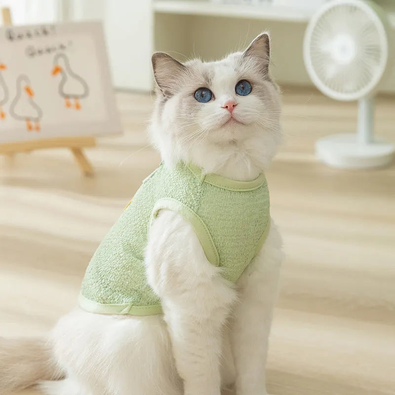 Green knitted cat clothing with a hollowed-out bear patch cartoon design.