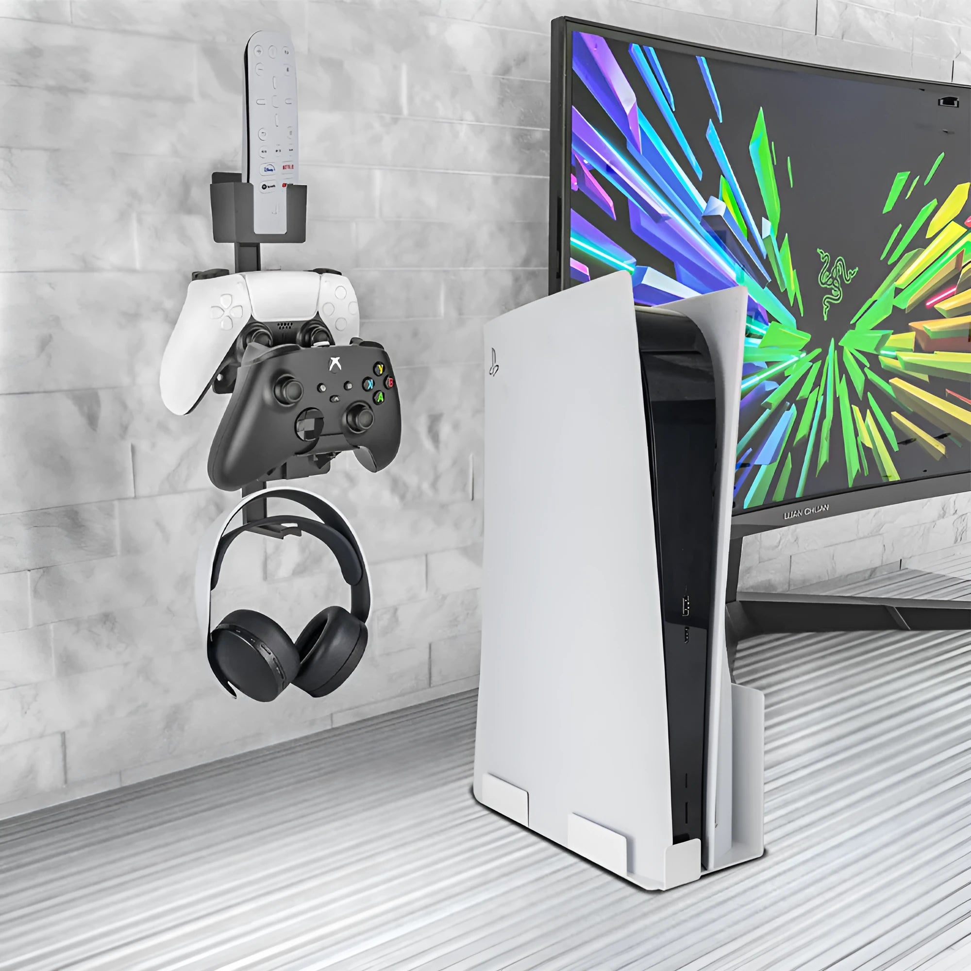 White ABS plastic wall hook holding a black game controller and TV remote.