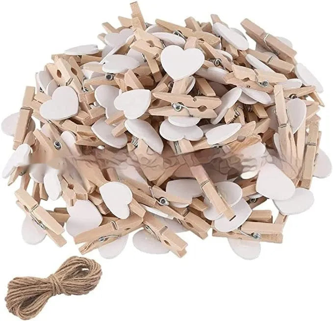 Five wooden heart-shaped clips in different colours on wooden surface