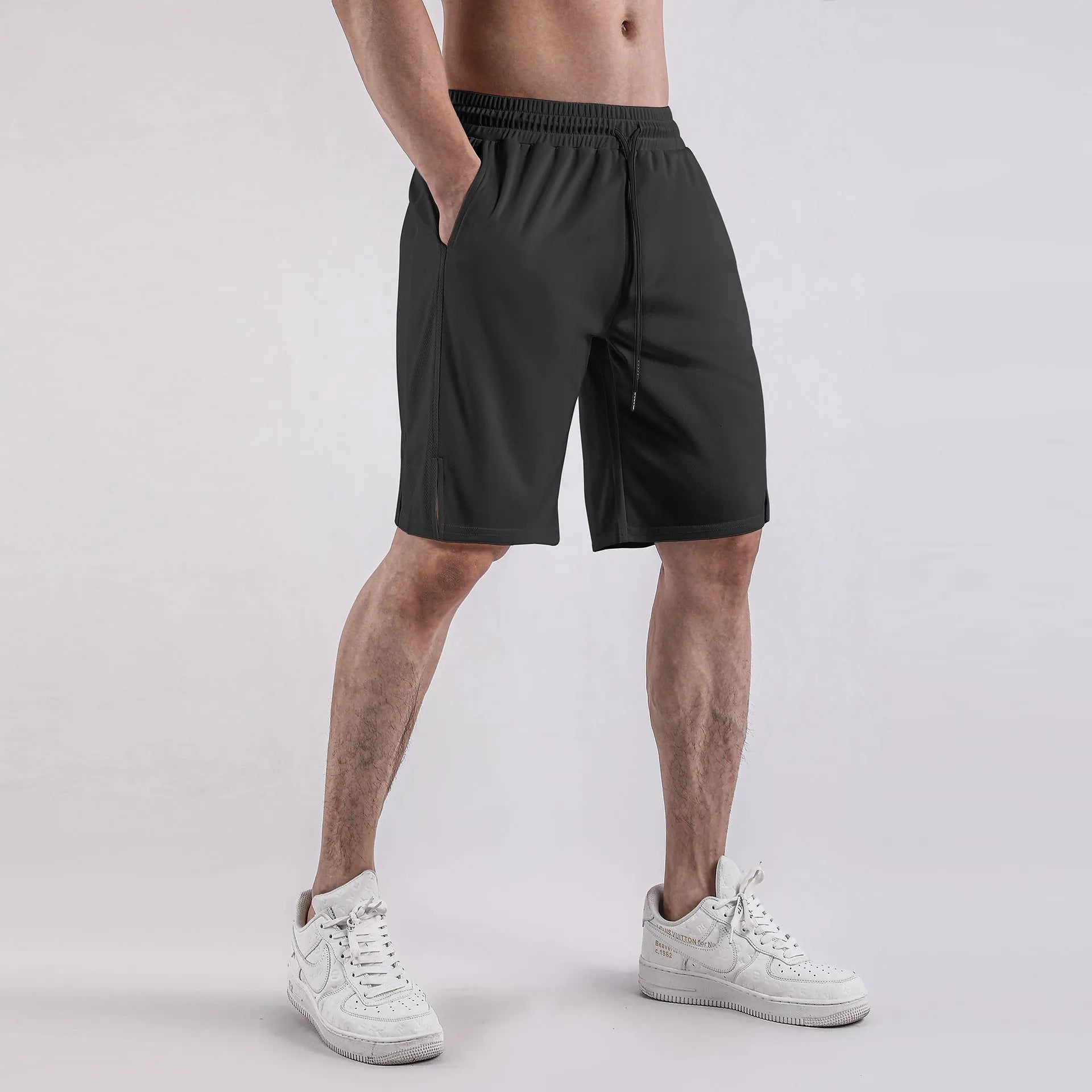 Men's black quick-dry mesh fitness shorts with elastic waistband laid flat.