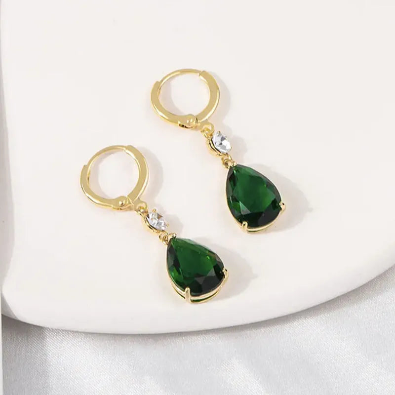 Green geometric teardrop alloy earrings with post findings on plain background