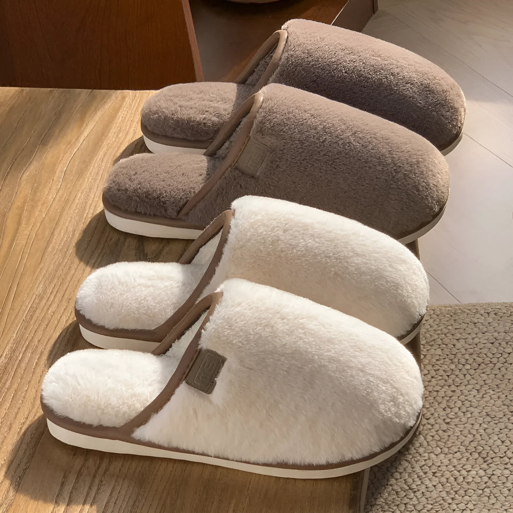 Solid colour winter plush slippers with non-slip PVC sole on a wooden floor.