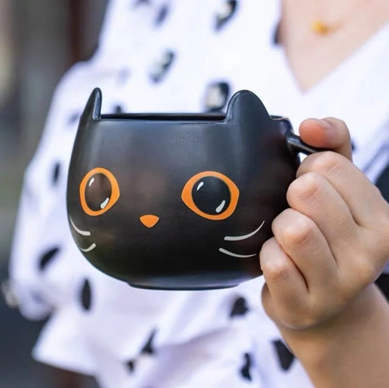 Black ceramic cat-shaped mug with pumpkin covered spoon on side
