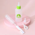 Four pet milk bottles in yellow, pink, blue, and green with cleaning brush on light background