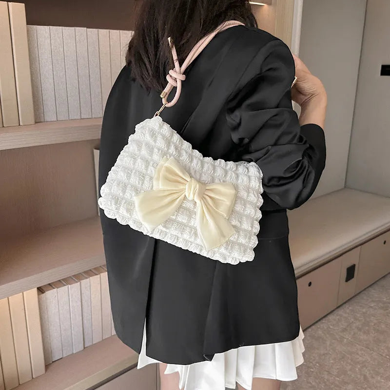 Black canvas horizontal square women's handbag with a single shoulder strap and an outer sandwich pocket.