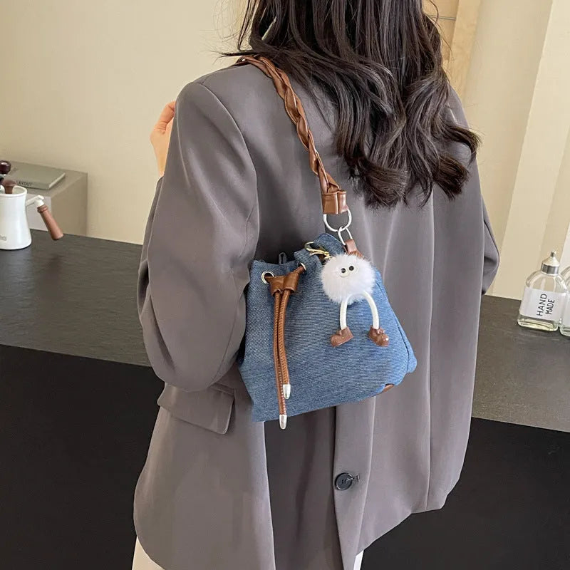 Blue synthetic leather cross body bucket bag with one-shoulder strap and outer pocket