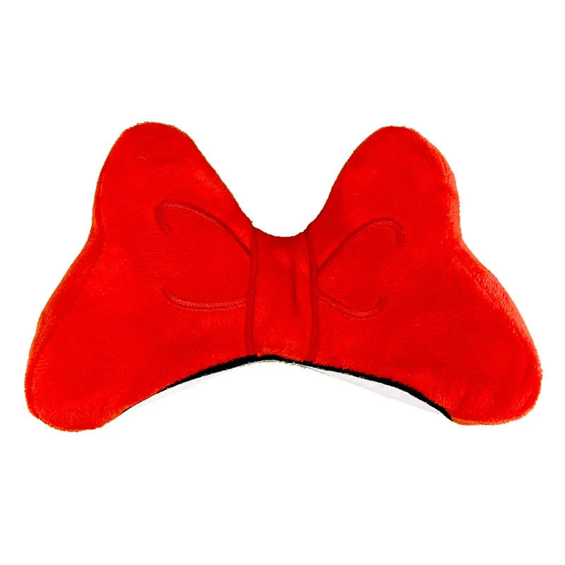 Plush bow tie helmet decoration in red, peach pink, and rose pink colours shown on a motorcycle helmet.