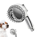 Silver dog shower attachment with soft silicone comb teeth and ergonomic grip on a white background