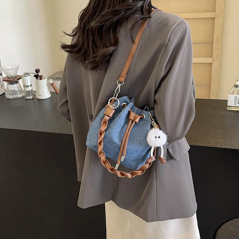 Blue synthetic leather cross body bucket bag with one-shoulder strap and outer pocket