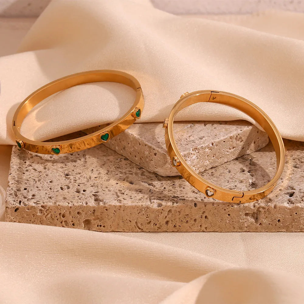 Women's stainless steel bracelet with a micro-inlaid peach heart charm in a golden electroplated colour.