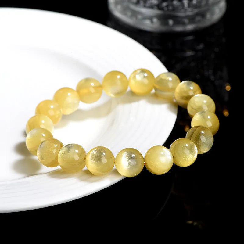 Polished natural mica round beads bracelet in yellow Lepidolite colour on flat surface