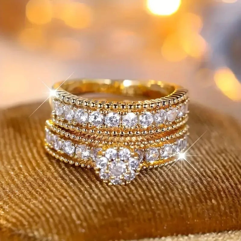 Two gold geometric zinc alloy rings with electroplated finish on white background