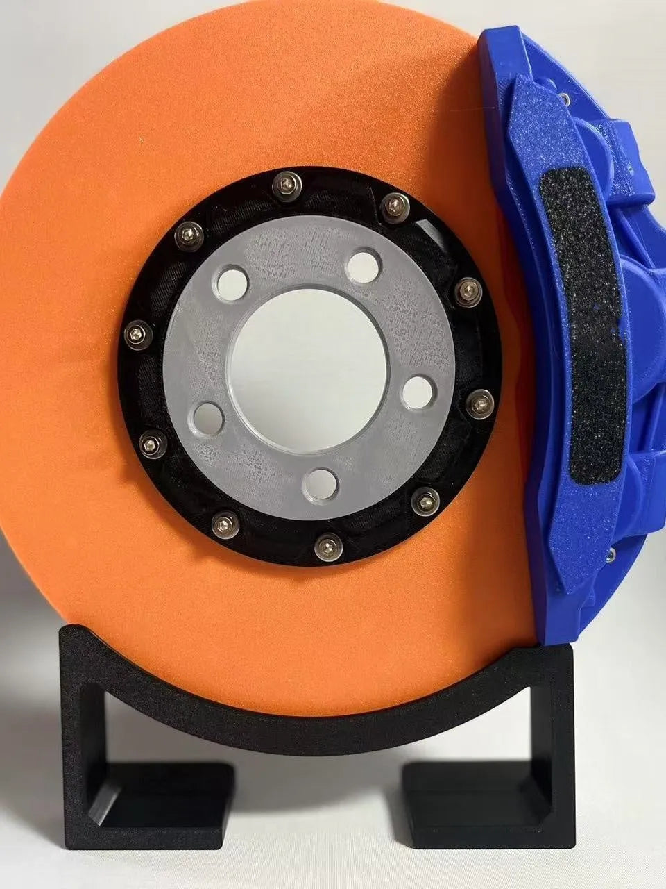 Rechargeable brake disc LED night light with touch dimmer, blue caliper colour, on a desk