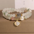 Women's crystal bracelet with green ginkgo leaf pendant, gold accents and rhinestones