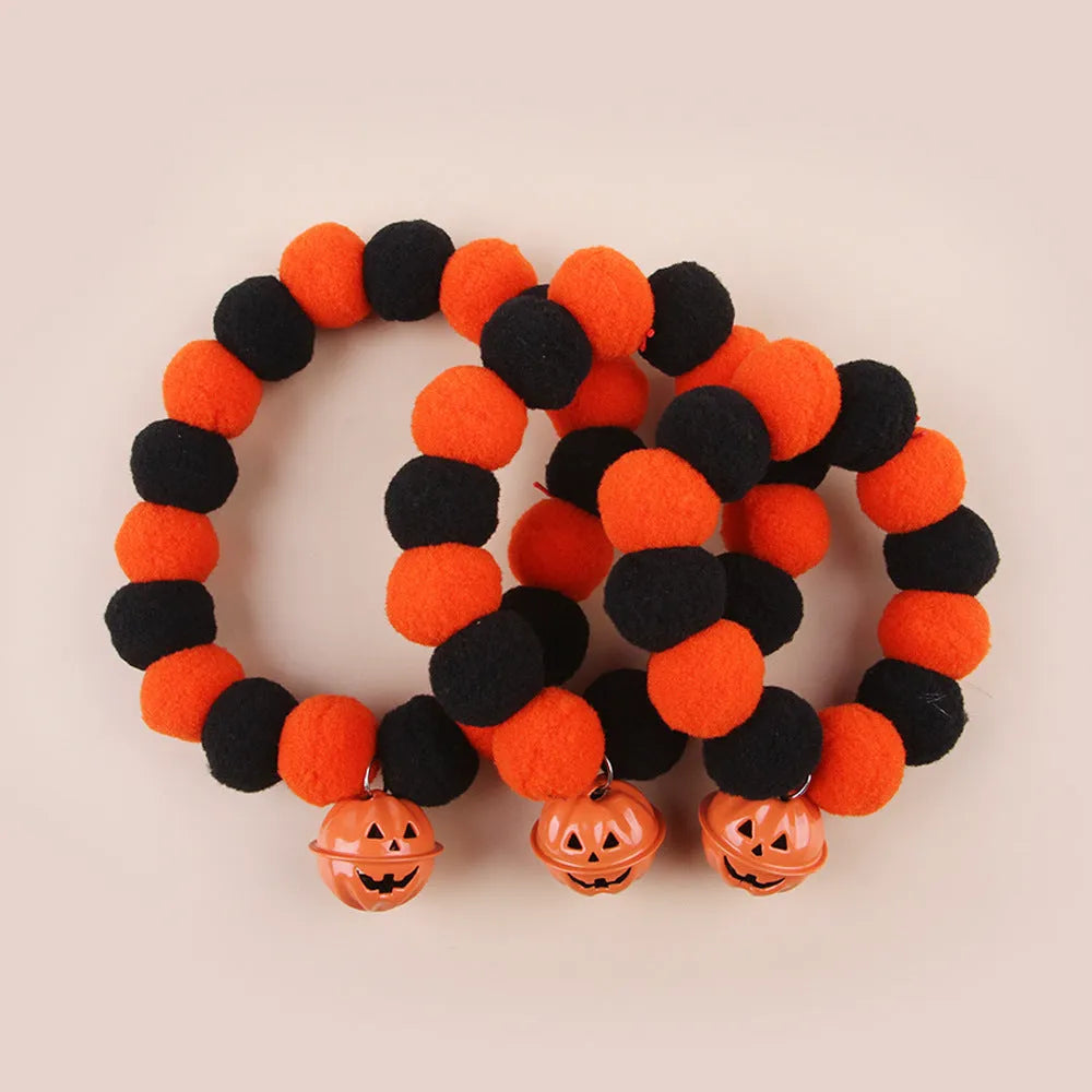 Orange Halloween pet collar for cats with pumpkin pattern and Trick or Treat text, showing plastic buckle.