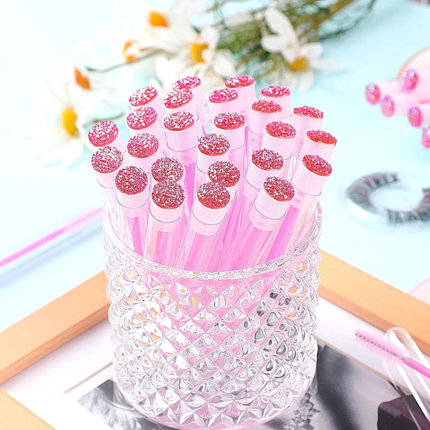 Disposable eyelash brushes in blue, green, pink, and purple colours with transparent storage tubes
