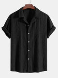 A man wearing a loose-fit black short-sleeve cardigan shirt for casual summer wear.