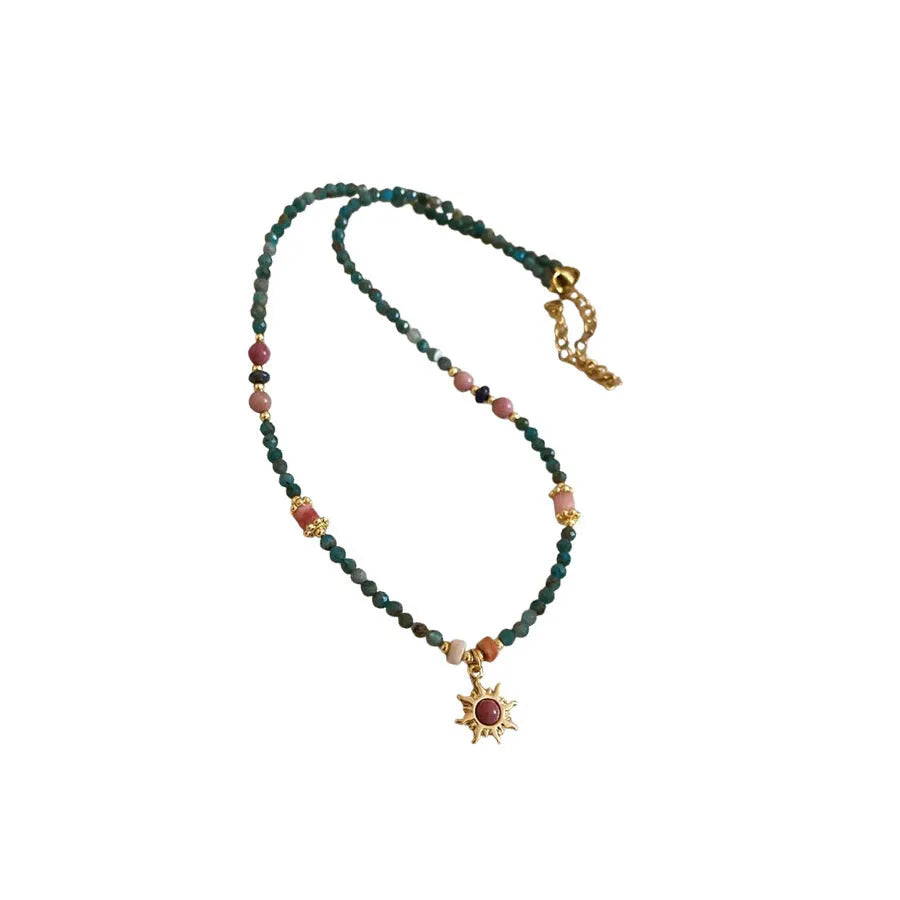 French royal style sun necklace with stone pendant, electroplated finish, and stringed freshwater pearls on a clavicle chain.