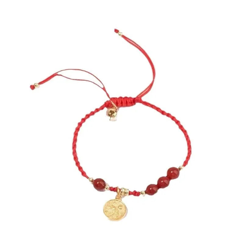 Cinnabar round bead blessing card bracelet with adjustable braided rope on neutral background