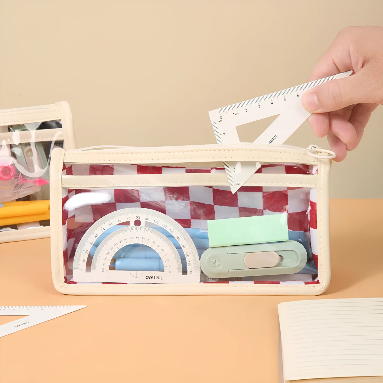 Transparent PVC pencil case with chessboard pattern showing writing instruments inside