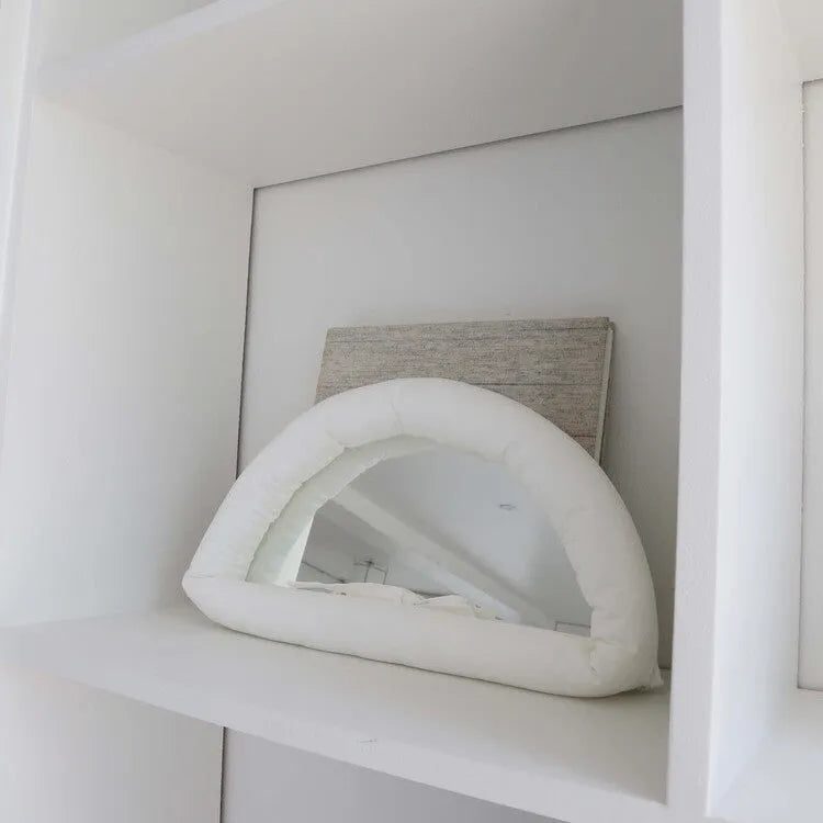 Soft cotton-filled fabric mirror in solid colour hanging as a background prop