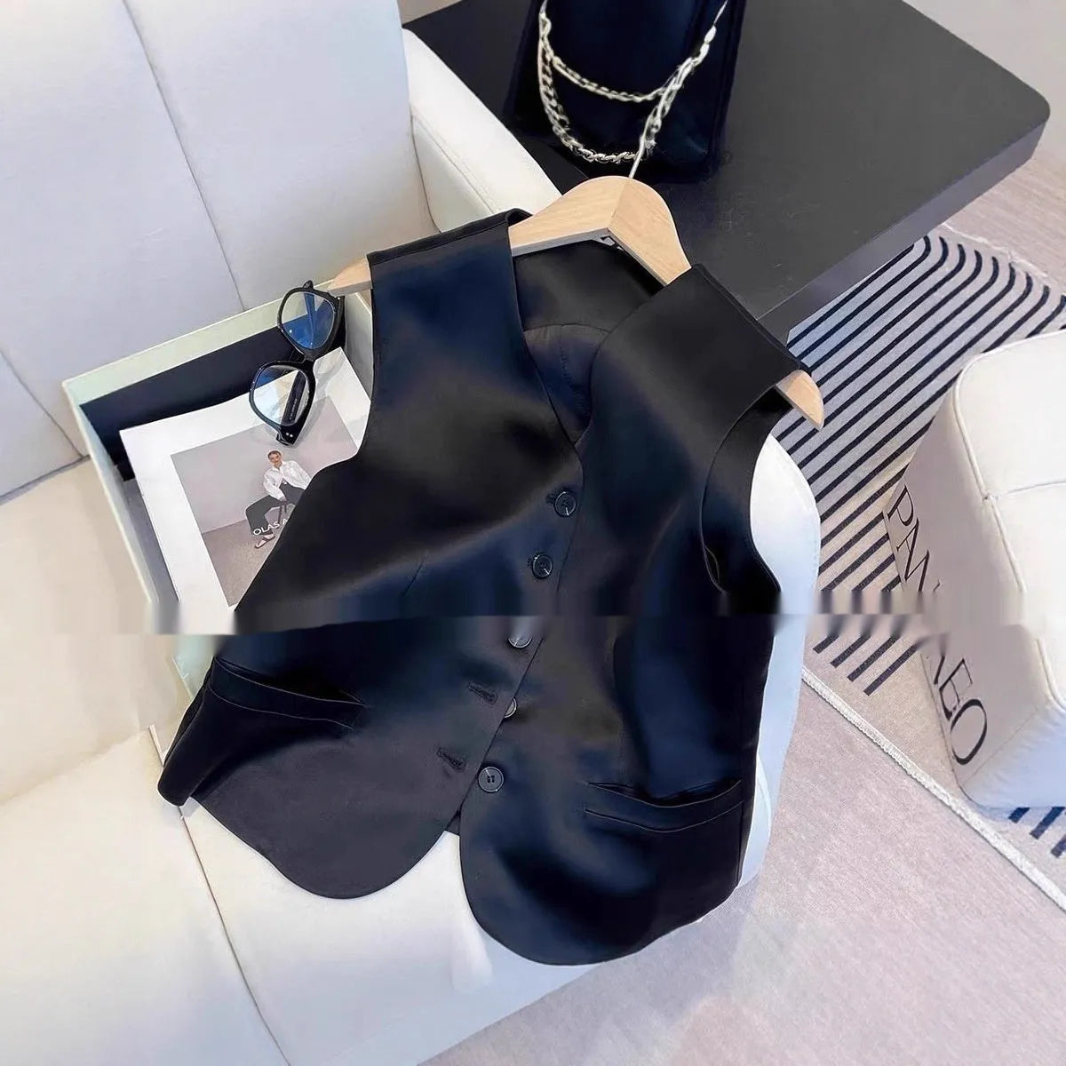 Black satin women's sleeveless vest with V-neck and loose fit on hanger