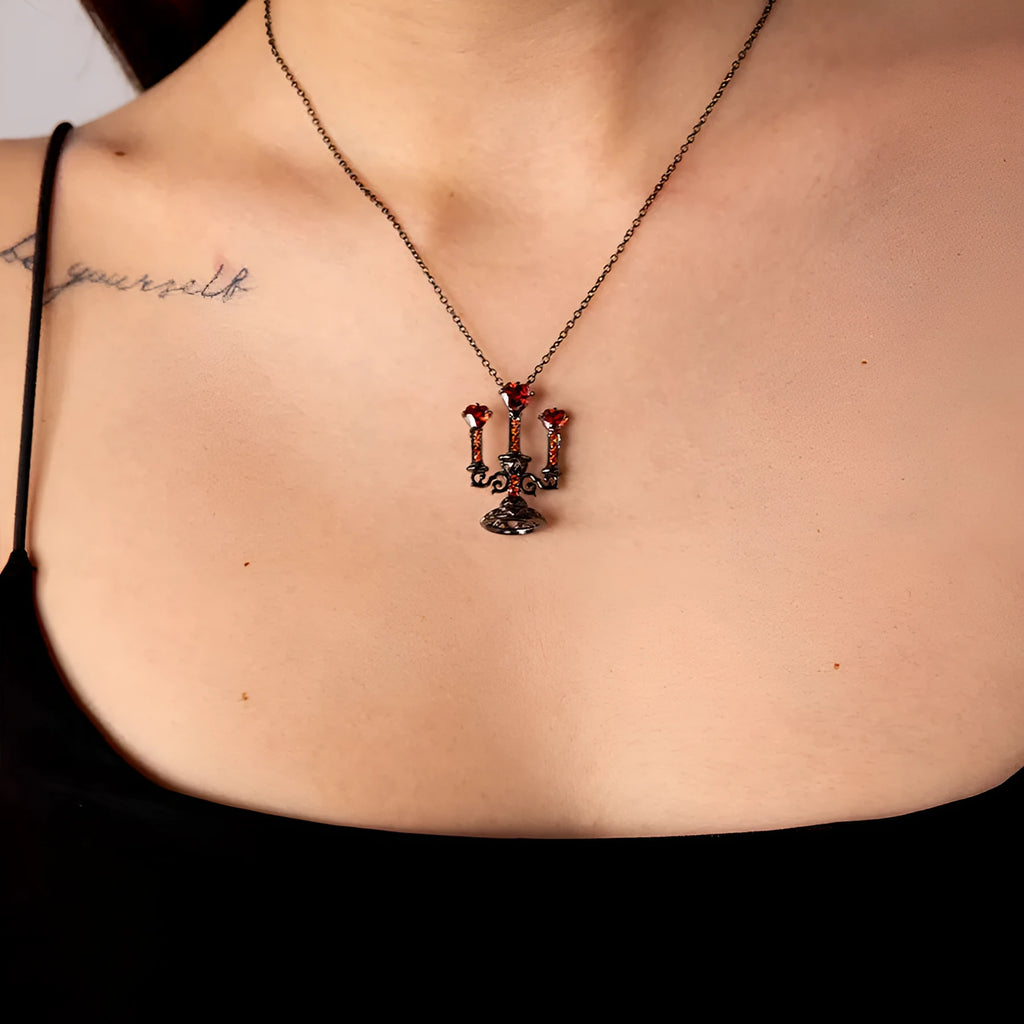 Close-up of a women's Gothic alloy necklace with a hollow candlestick pendant and cross chain links.