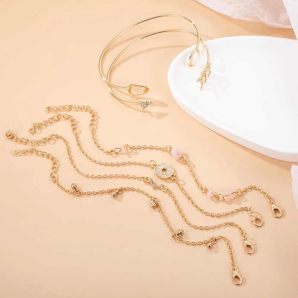 Women's gold colour bracelet set with 6 pieces showing water drop V-shaped pendants and drill arrow designs