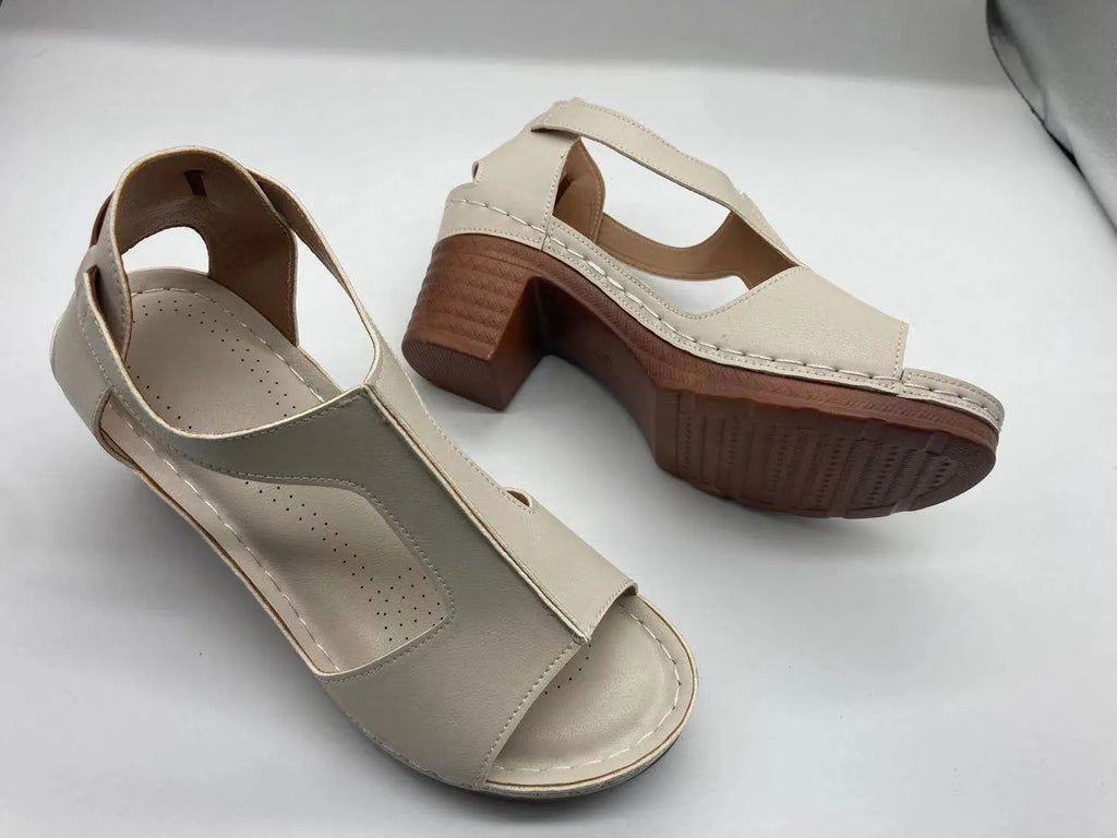 Women's beige peep toe wedge sandals with Roman ankle straps and a buckle closure on a low heel.