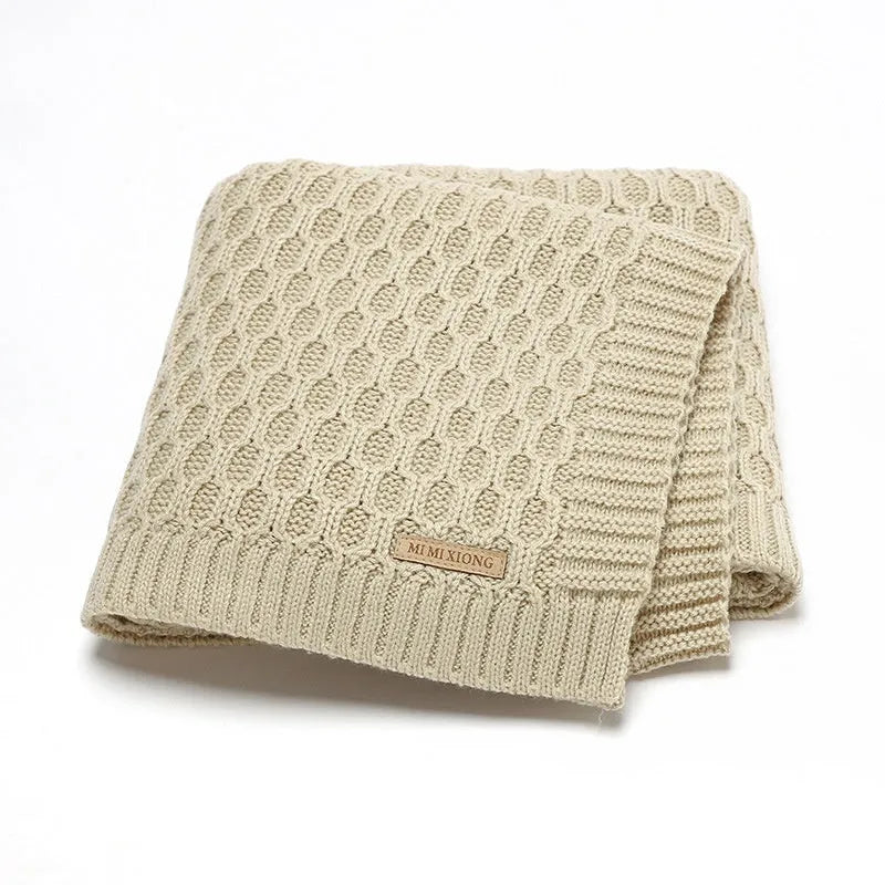 Solid colour acrylic baby blanket with textured lines, shown in a neutral shade, dimensions 70x90 cm