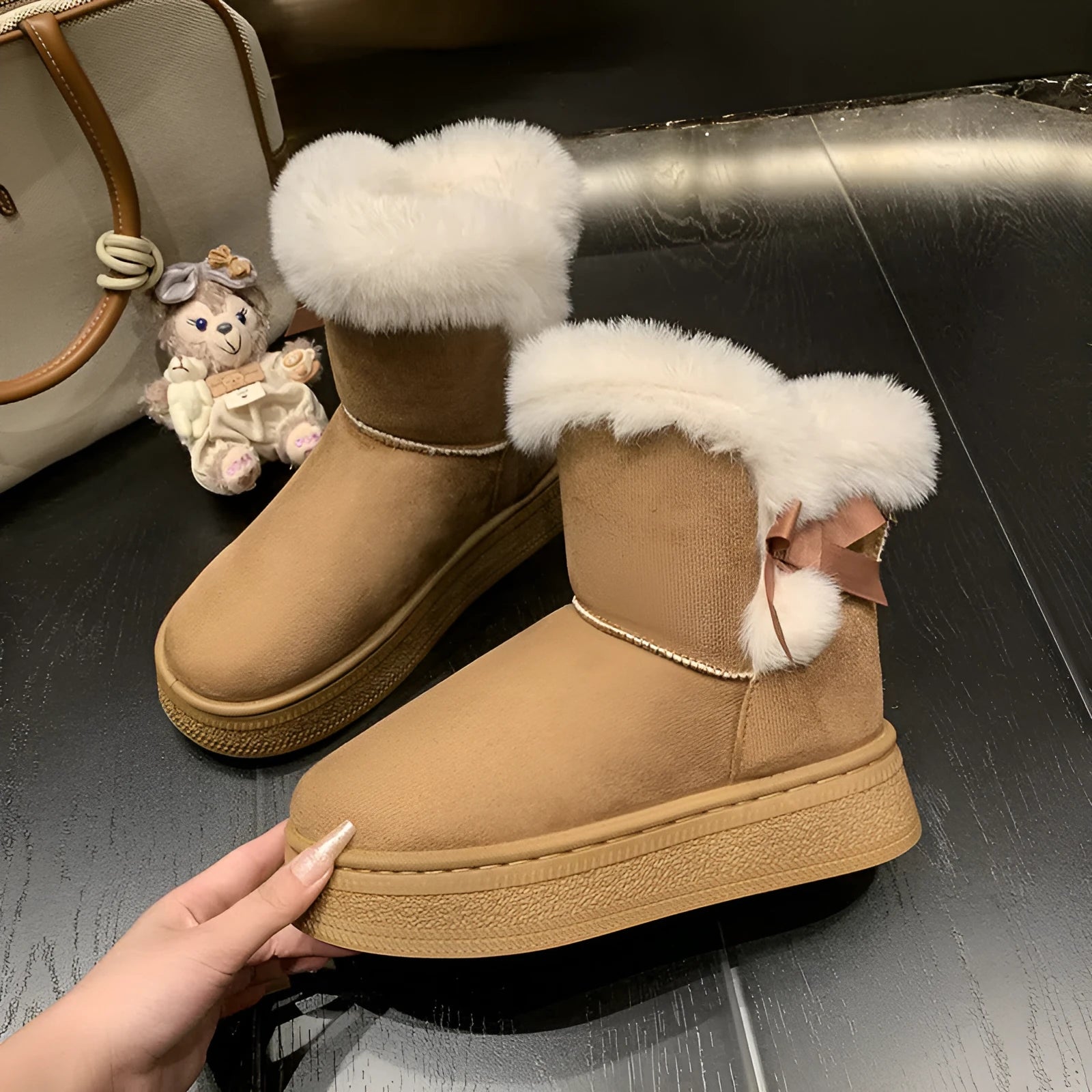 Women's mid-calf fleece-lined snow boots in brown with black rubber sole and bow tie detail