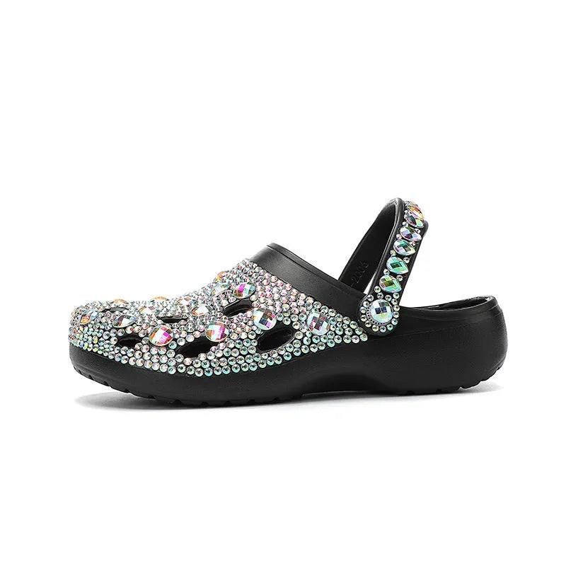 Black platform sandals for women with rhinestone decoration and a hole design upper on a white background.