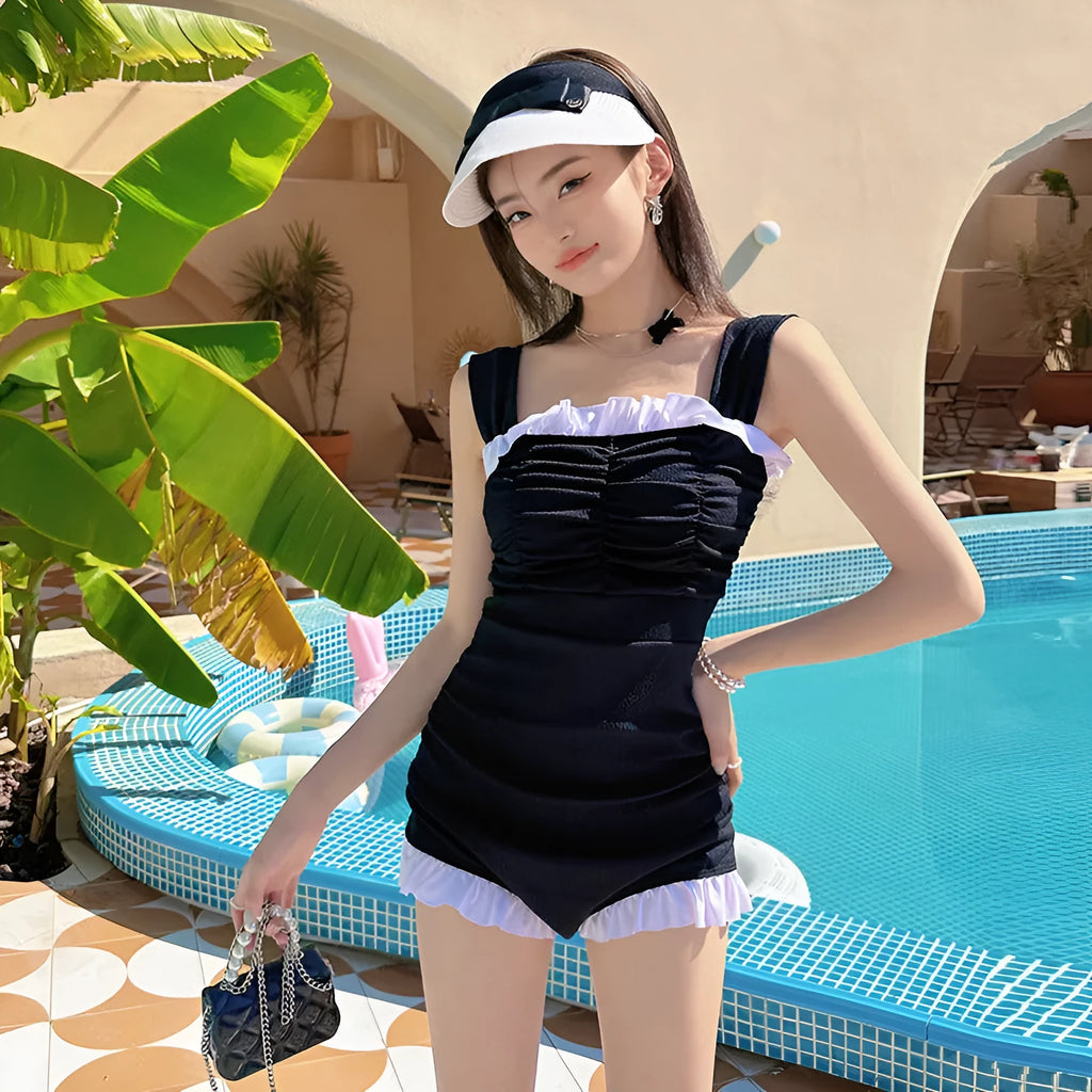 Women's solid colour one-piece suspender swimsuit in black, front view, polyester fibre, sizes S to XL