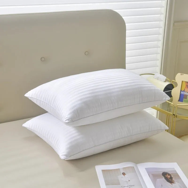 White cotton satin stripe pillow with feather and cotton filling shown in adult bedding setting.