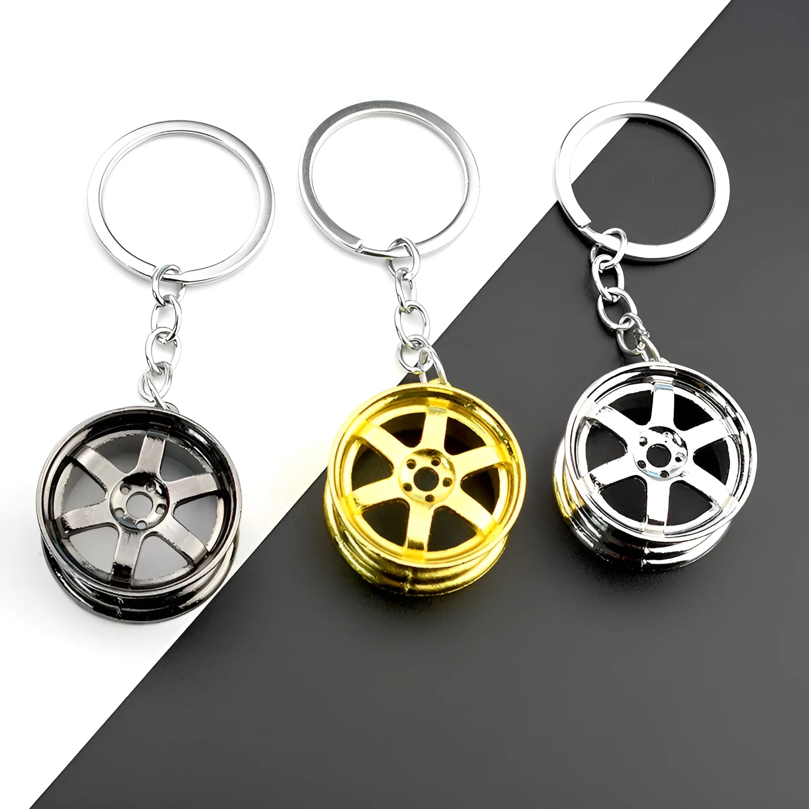 Zinc alloy car wheel hub keychain in gold finish with detailed hub pattern on white background