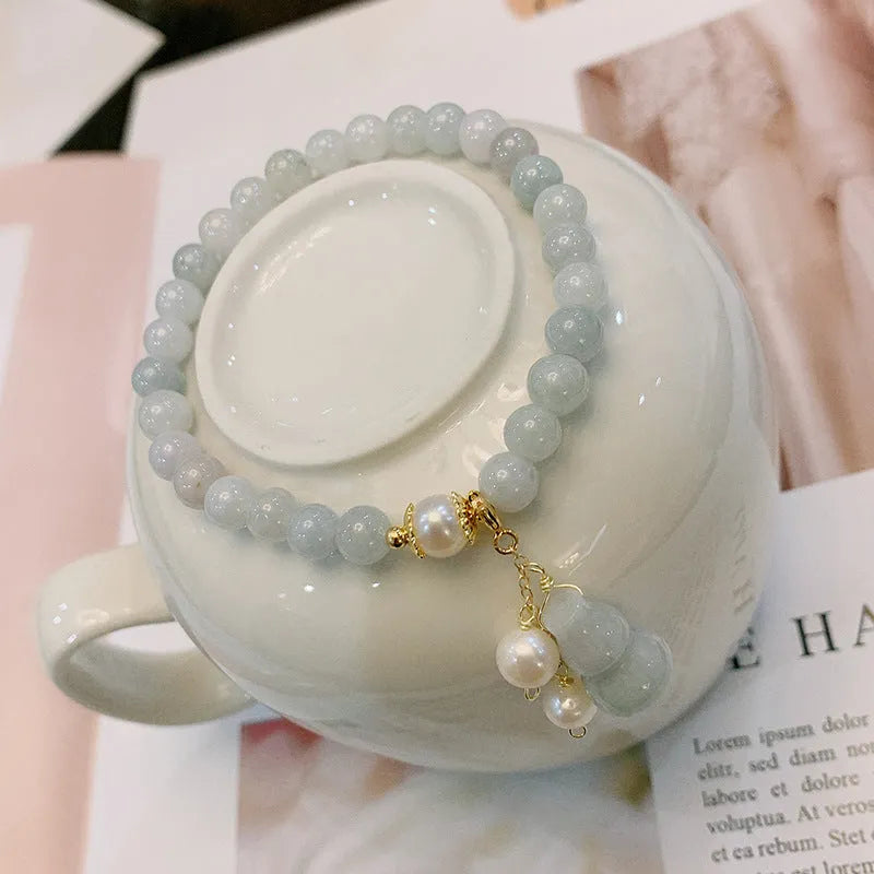 Close-up of a Chinese style jade bracelet for women featuring a natural emerald jade gourd charm on a band.