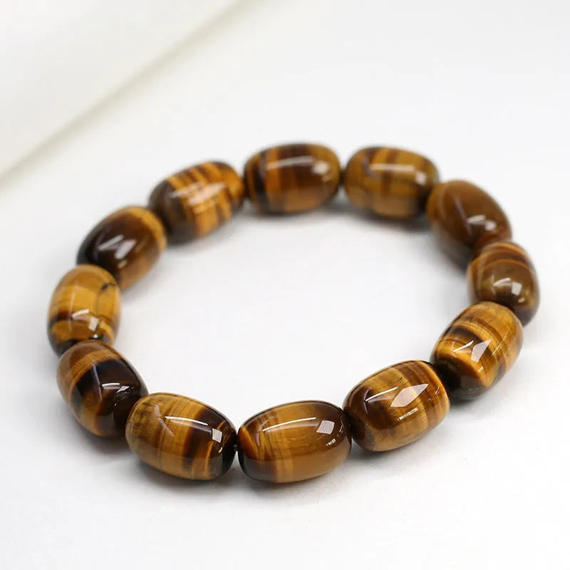 Natural yellow tigereye bracelet with sunny cat eye effect, ball beads in 11x16mm size on light background