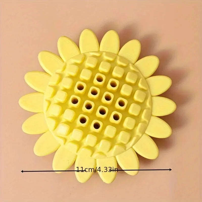 Yellow rubber sunflower dog chew toy on a surface, non toxic and BPA free for puppy teething