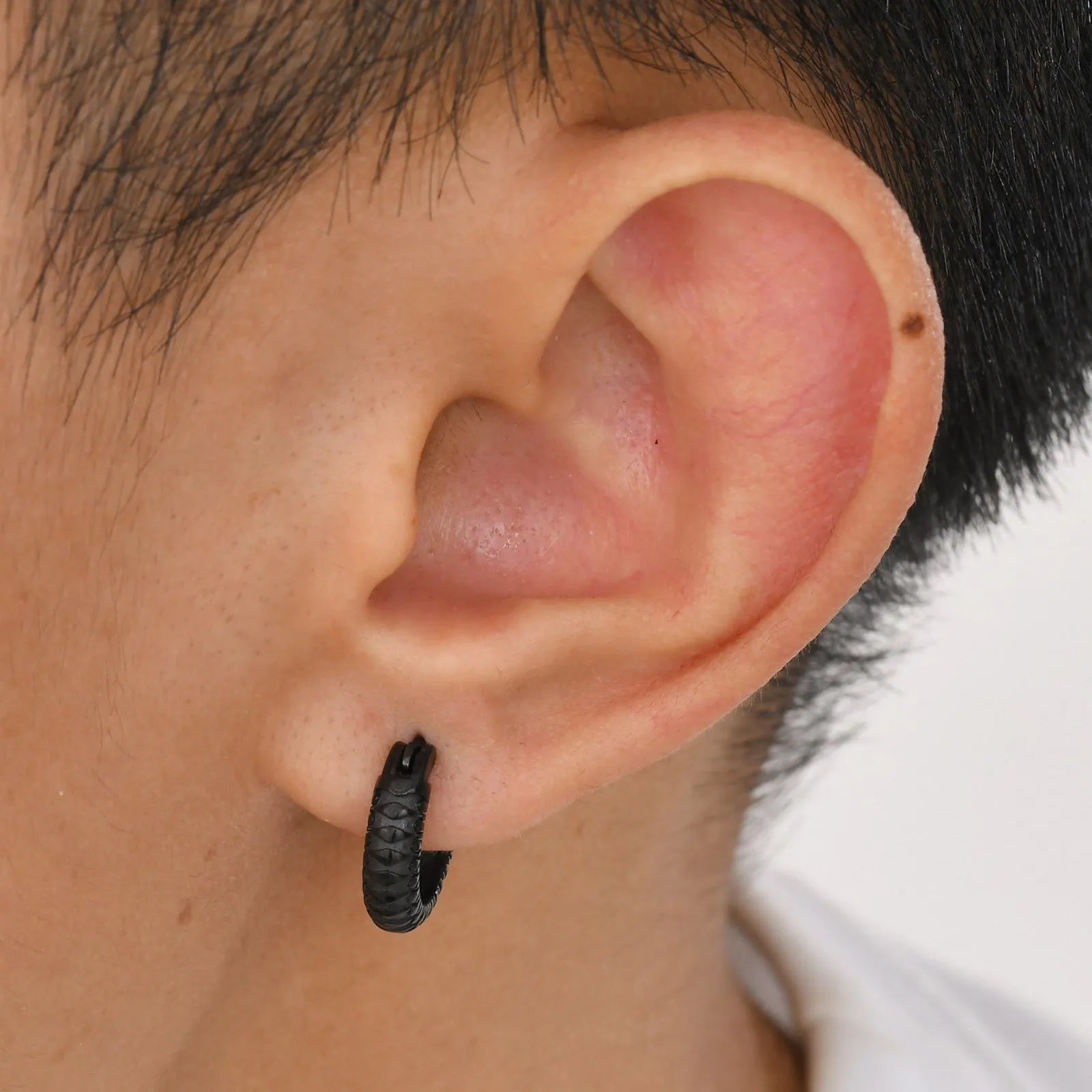 Stainless steel snake pattern earrings in black and gold finish, 30mm diameter