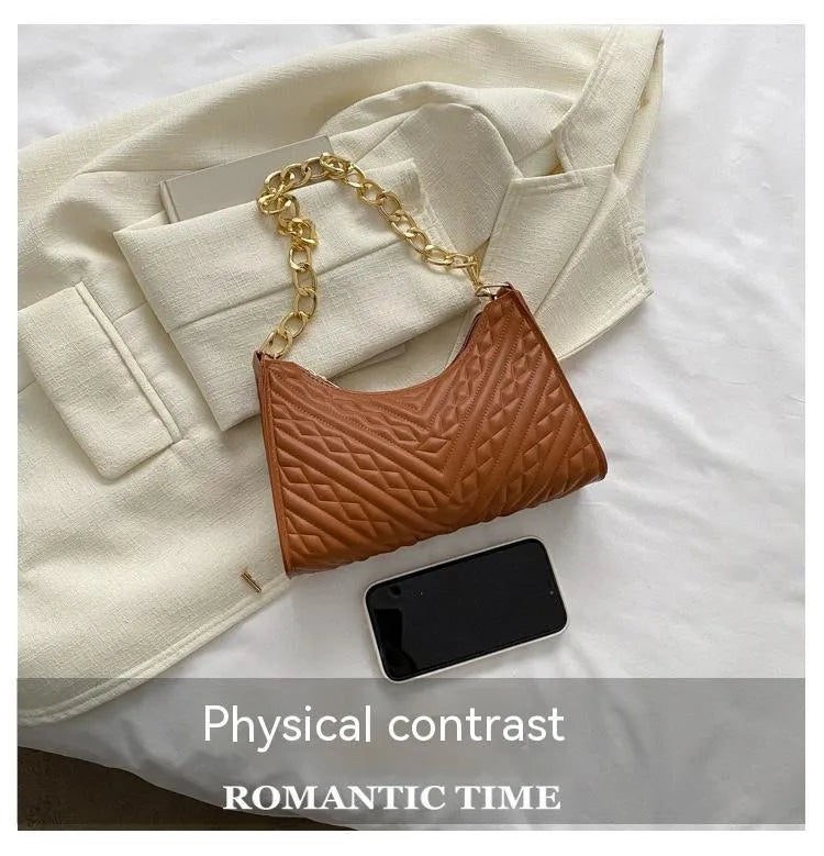 Black pleated chain baguette shoulder bag with adjustable strap and soft handle on white background